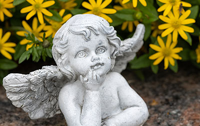 Angel on a tombstone with yellow flowers