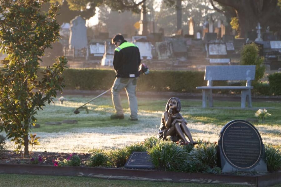 Man trimming the grass at Southern Metropolitan Cemeteries NSW.